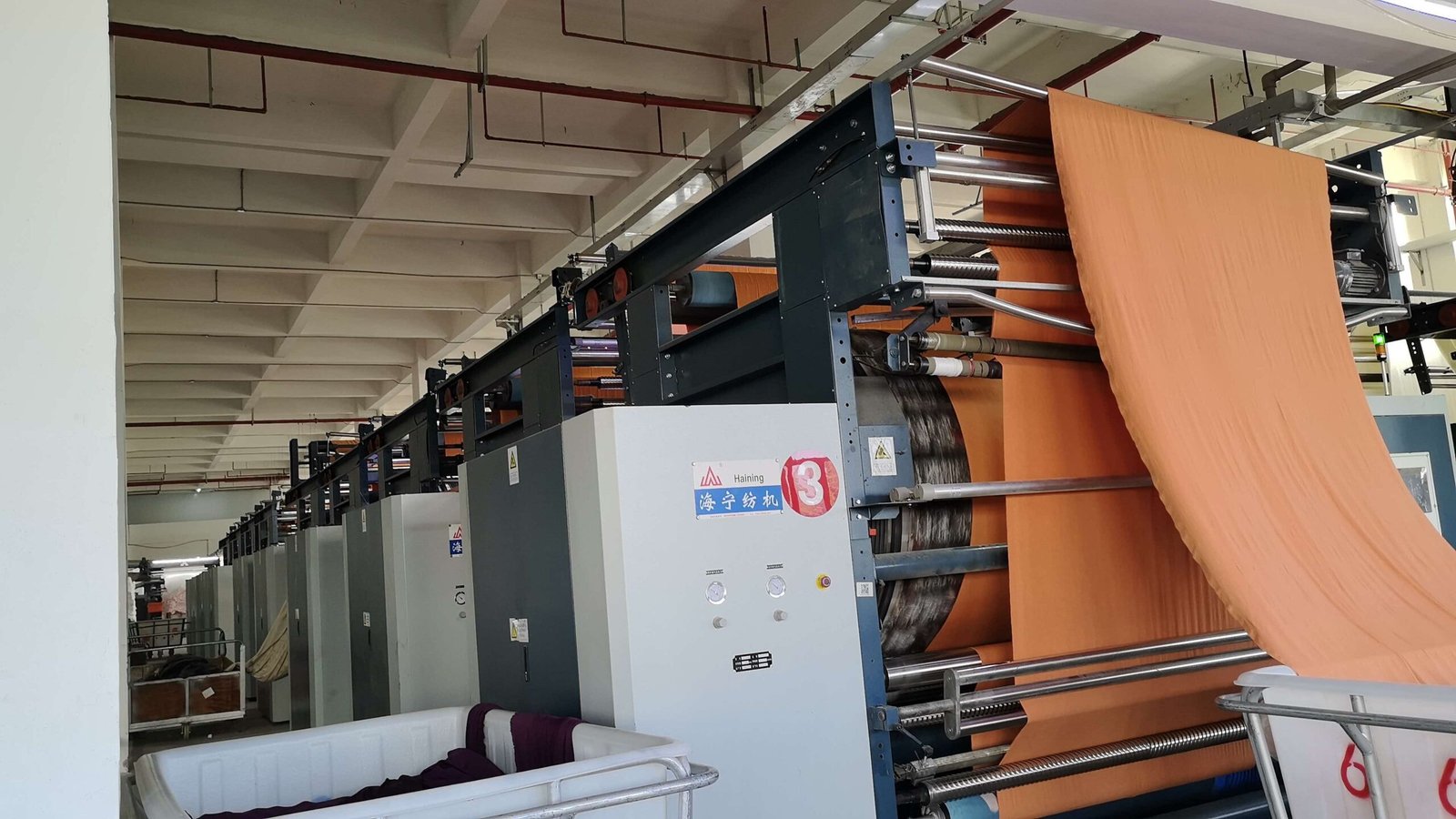 Circular knitting machine with yarn creels at the Even Fabric factory.